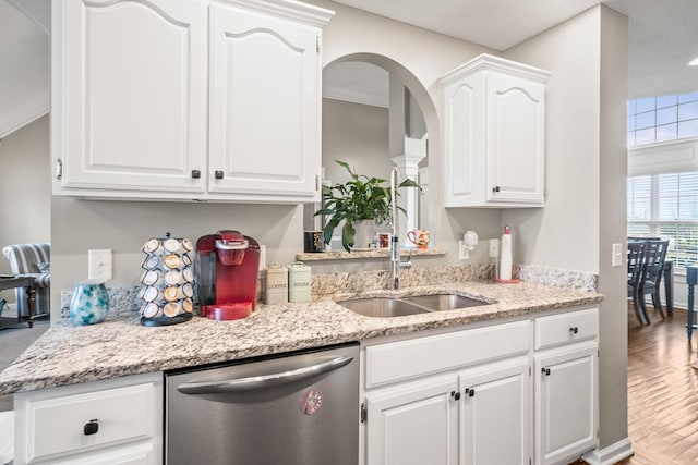 kitchen featuring stainless steel dishwasher, wood finished floors, light stone countertops, and white cabinets