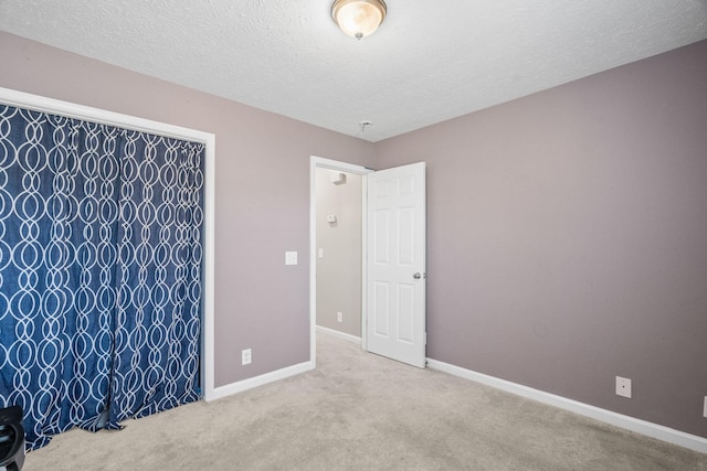 carpeted spare room featuring a textured ceiling