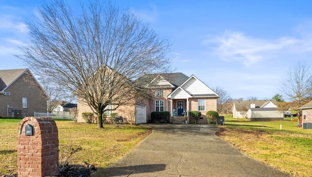 traditional-style house with brick siding, a front yard, fence, a garage, and driveway