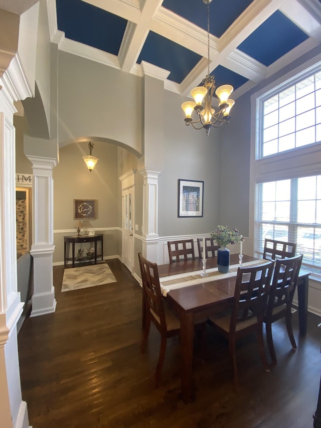 dining room with decorative columns, arched walkways, coffered ceiling, a towering ceiling, and dark wood-style floors