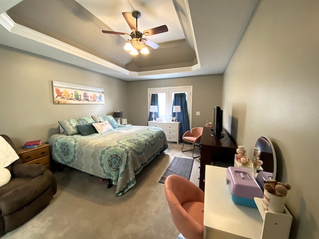 bedroom with ceiling fan, a tray ceiling, carpet flooring, and ornamental molding