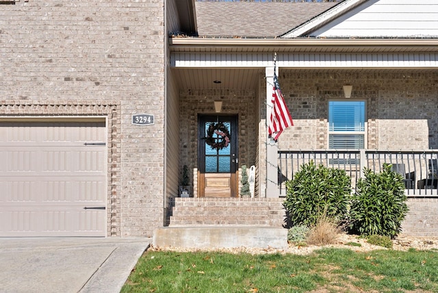 doorway to property with covered porch and a garage