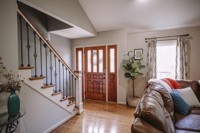 entrance foyer with light hardwood / wood-style floors and vaulted ceiling