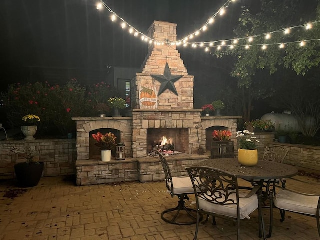 patio at night with an outdoor stone fireplace