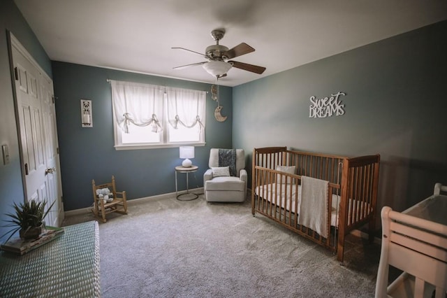 carpeted bedroom with ceiling fan, a closet, and a nursery area