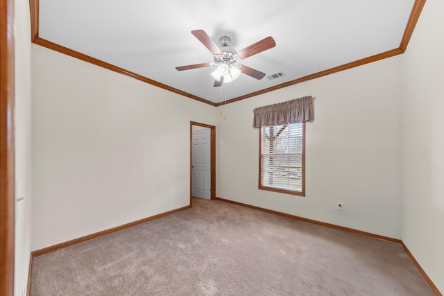 empty room featuring ceiling fan, ornamental molding, and light carpet