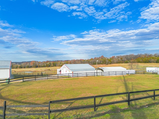 view of yard with a rural view and an outdoor structure