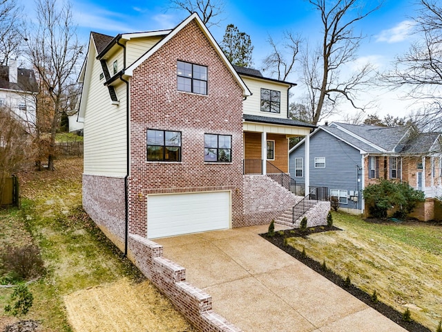 traditional home with concrete driveway, an attached garage, stairs, a front lawn, and brick siding