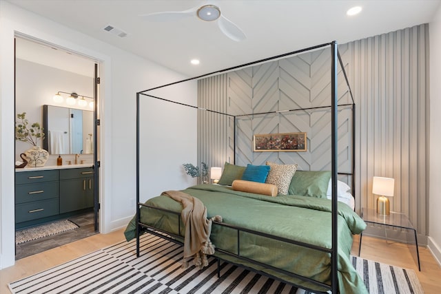 bedroom with recessed lighting, light wood-style floors, a ceiling fan, a sink, and ensuite bath