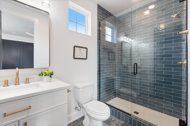 bathroom with toilet, a stall shower, baseboards, and vanity