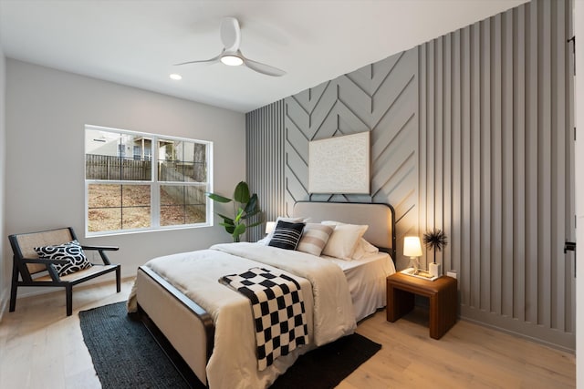 bedroom with an accent wall, recessed lighting, light wood-style flooring, and wallpapered walls