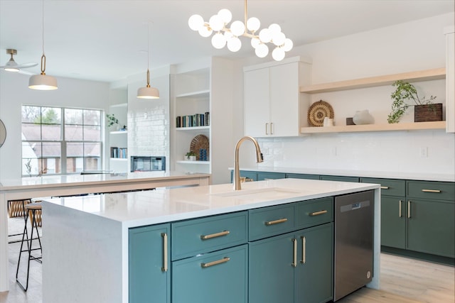 kitchen featuring a sink, white cabinetry, stainless steel dishwasher, open shelves, and an island with sink