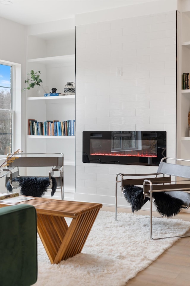 office space featuring a fireplace, built in features, and wood finished floors