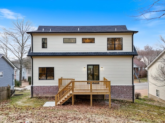 rear view of house featuring a deck, a shingled roof, and stairs