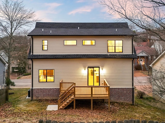 back of property featuring a shingled roof, stairway, and a wooden deck