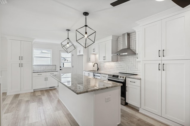 kitchen featuring white cabinetry, stainless steel electric range oven, a center island, wall chimney exhaust hood, and pendant lighting