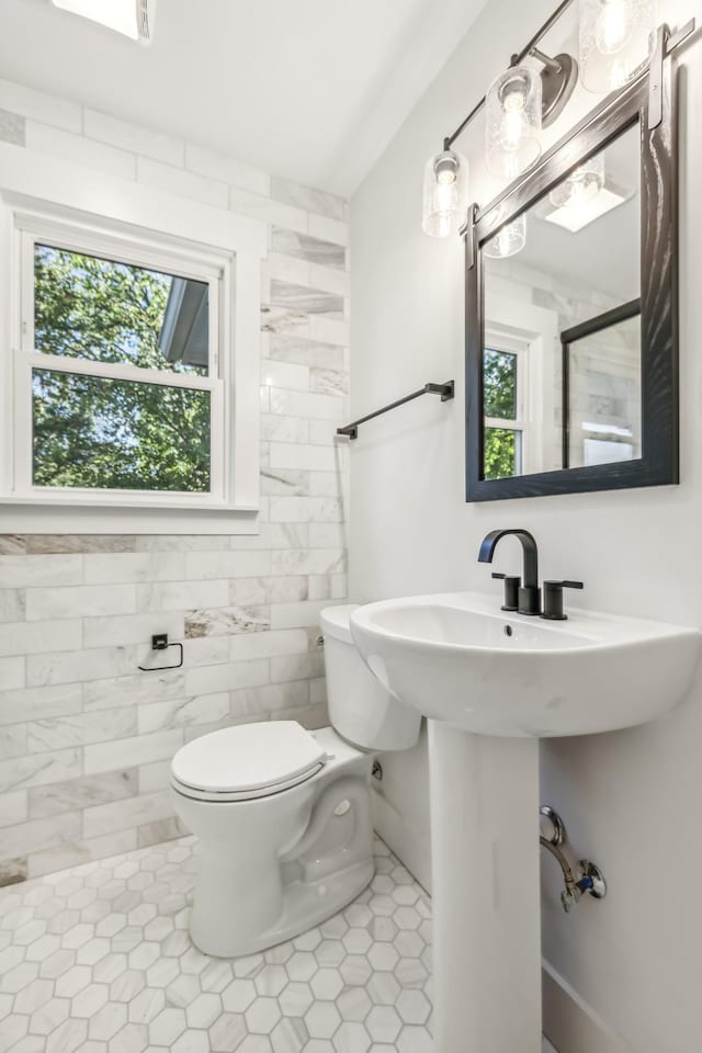 bathroom with tile patterned floors, a healthy amount of sunlight, and toilet