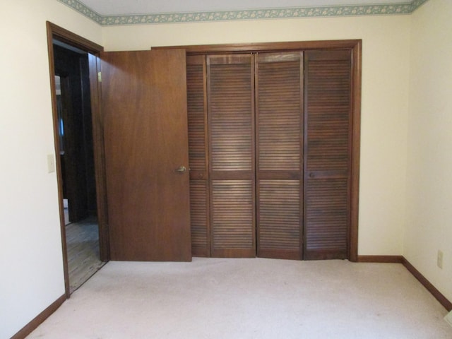 unfurnished bedroom featuring light carpet and a closet