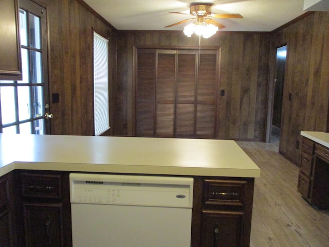 kitchen with dishwasher, wood walls, ceiling fan, dark brown cabinets, and light hardwood / wood-style floors