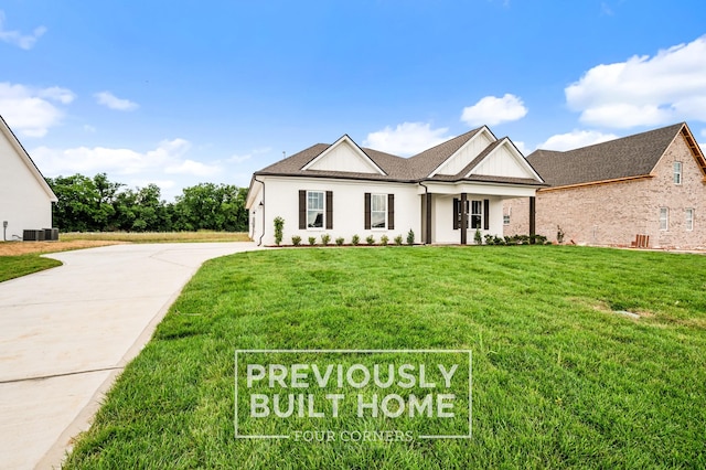 view of front of property with central AC unit and a front lawn