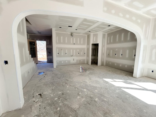 unfurnished living room with arched walkways