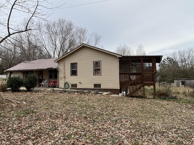 back of property with a patio area and a sunroom