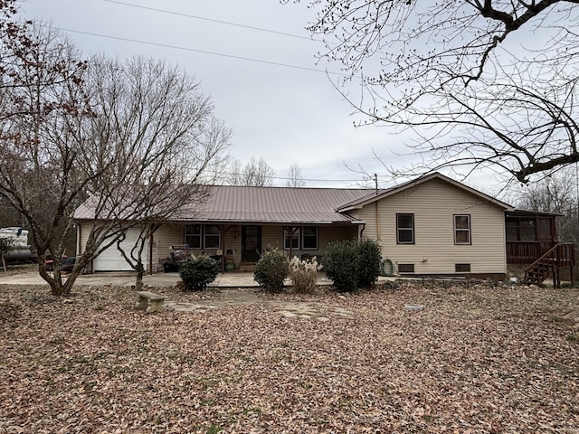 view of front of home featuring a garage and a sunroom