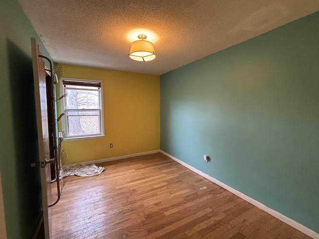 unfurnished room with light hardwood / wood-style floors and a textured ceiling