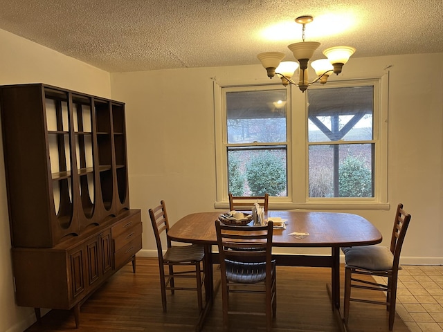 dining space featuring a chandelier, hardwood / wood-style floors, and a textured ceiling