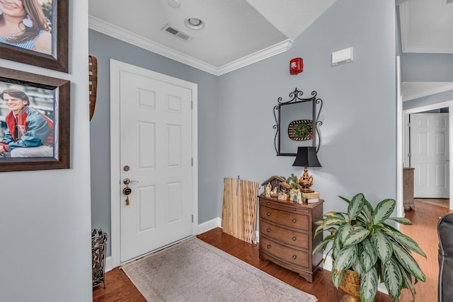 entryway with vaulted ceiling, crown molding, and dark wood-type flooring