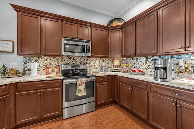 kitchen with backsplash, light hardwood / wood-style flooring, ornamental molding, and appliances with stainless steel finishes