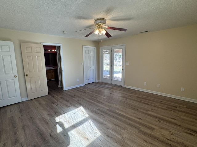 unfurnished bedroom featuring access to exterior, french doors, a textured ceiling, ceiling fan, and dark wood-type flooring