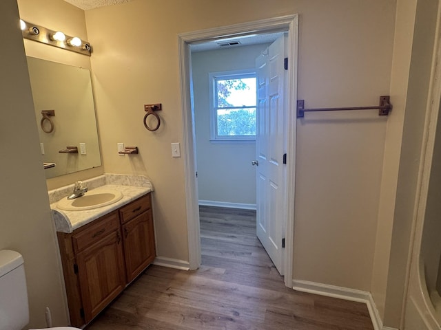 bathroom featuring hardwood / wood-style floors, vanity, and toilet