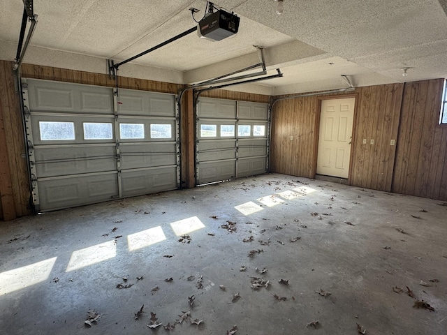 garage with wood walls and a garage door opener