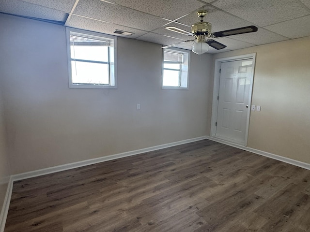 unfurnished room featuring a drop ceiling, ceiling fan, and dark wood-type flooring