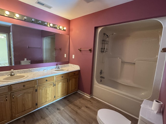 full bathroom with vanity, hardwood / wood-style flooring, toilet, and tub / shower combination