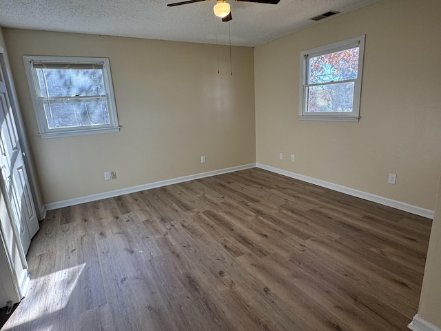 spare room featuring a textured ceiling, light wood-type flooring, and ceiling fan