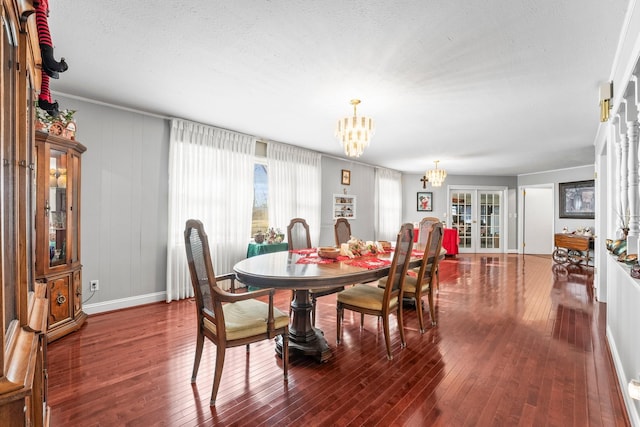 dining room featuring hardwood / wood-style floors, a textured ceiling, an inviting chandelier, and french doors