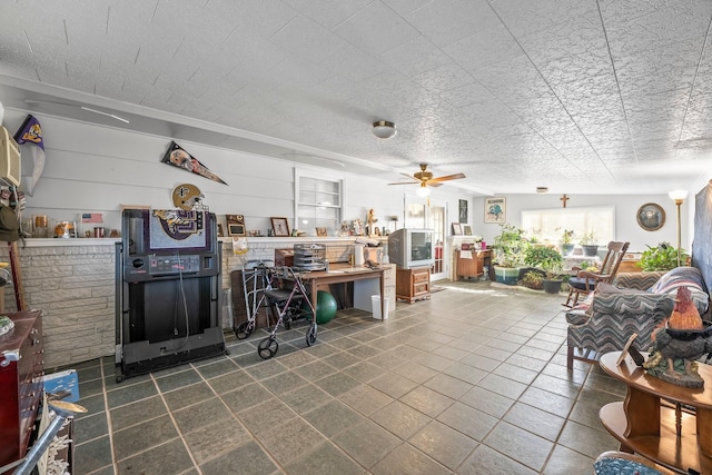 living room with ceiling fan and a textured ceiling