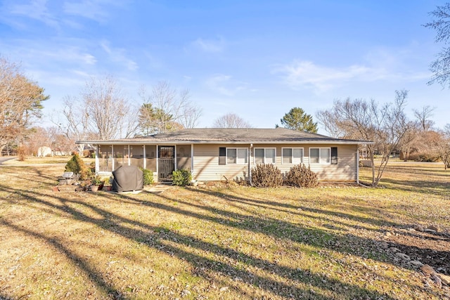 view of front facade with a front lawn and a sunroom