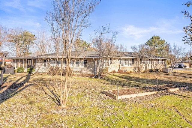 single story home featuring central AC, a sunroom, and a front lawn