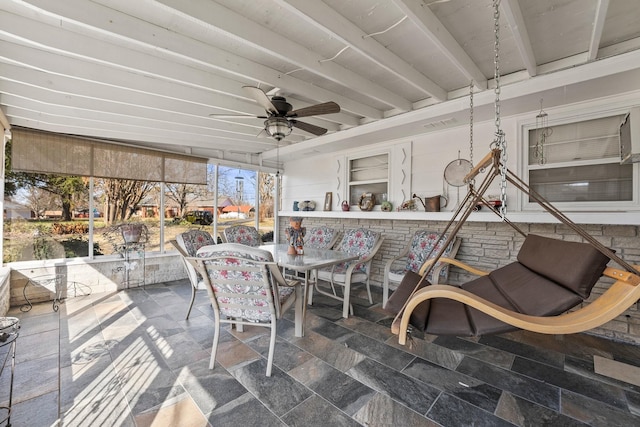 sunroom / solarium with ceiling fan and beamed ceiling