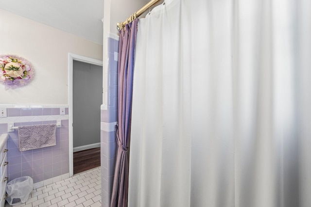 bathroom with tile patterned flooring, vanity, and tile walls