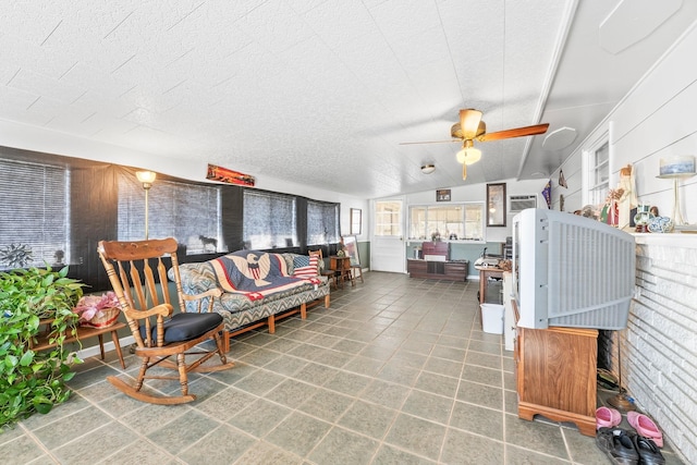 living room with a textured ceiling, wooden walls, ceiling fan, and lofted ceiling