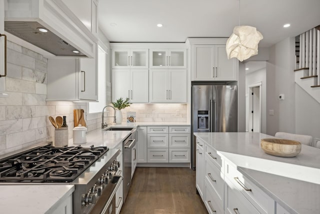 kitchen featuring light stone countertops, custom exhaust hood, and white cabinets