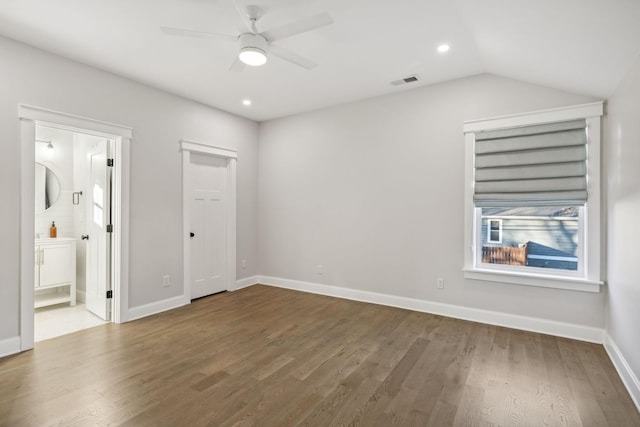 unfurnished bedroom with ceiling fan, vaulted ceiling, wood-type flooring, and ensuite bath