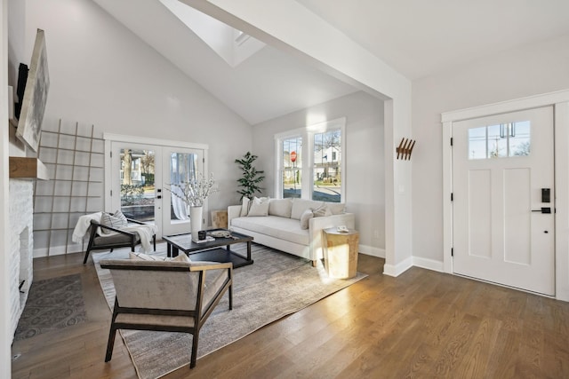 living room with a skylight, high vaulted ceiling, a wealth of natural light, and dark wood-type flooring