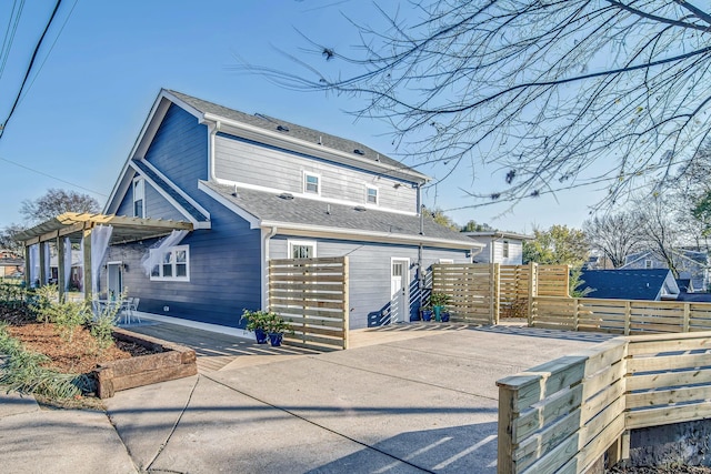 rear view of property featuring a pergola