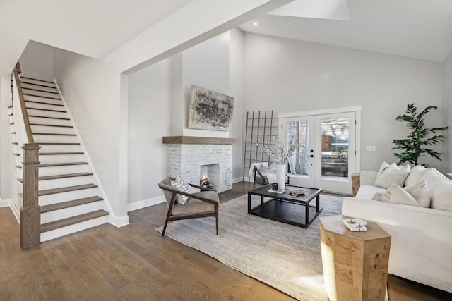 living room featuring a stone fireplace, french doors, high vaulted ceiling, and dark hardwood / wood-style floors