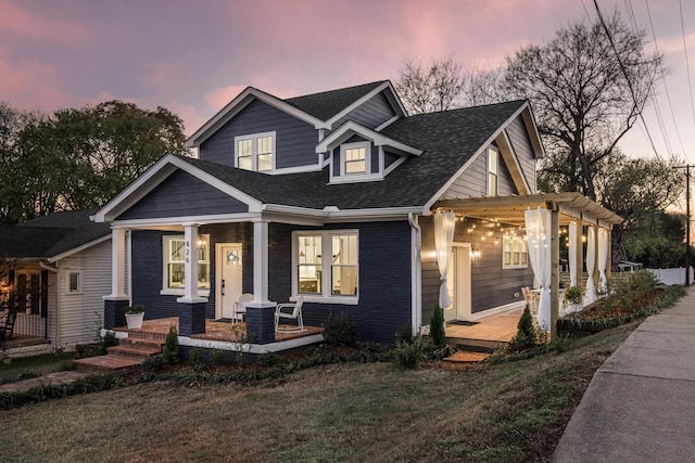 craftsman-style home featuring a pergola, a yard, and covered porch